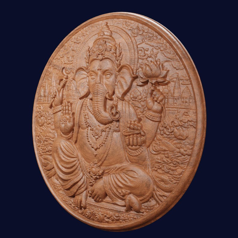 May include: A circular wooden wall plaque featuring a detailed relief carving of the deity Ganesha. The figure is depicted in a seated position with four arms, holding a lotus flower and other items, surrounded by intricate floral and temple motifs.