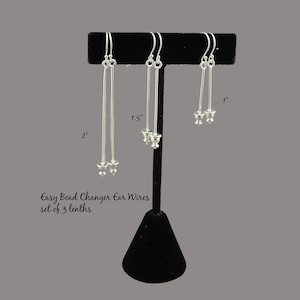 May include: Set of three silver bead changer ear wires, displayed on a black stand. The wires are 1 inch, 1.5 inches, and 2 inches long. Easy Bead Changer Ear Wires set of 3 lengths.