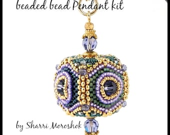 May include: A beaded pendant kit called "Jewel Box" by Sharri Moroshok. The pendant is a cube-shaped bead with a gold-colored metal bail and a purple crystal bead at the bottom.