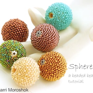 Könnte beinhalten: Sechs Perlenkugeln in verschiedenen Farben, darunter Türkis, Braun, Grün, Gold und Creme. Die Perlen bestehen aus kleinen Perlen und haben eine strukturierte Oberfläche. Das Bild enthält den Text "Spheres a beaded bead tutorial".