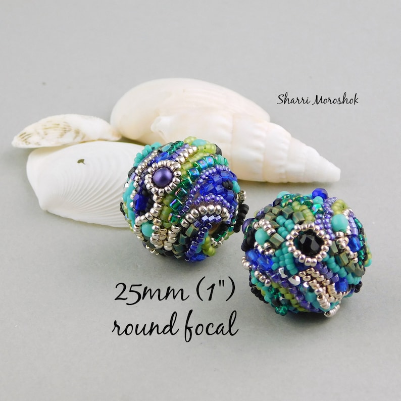 May include: Two 1 inch round beaded focal beads in shades of blue, green, turquoise, silver, and black. The beads are made with seed beads and feature a geometric pattern.