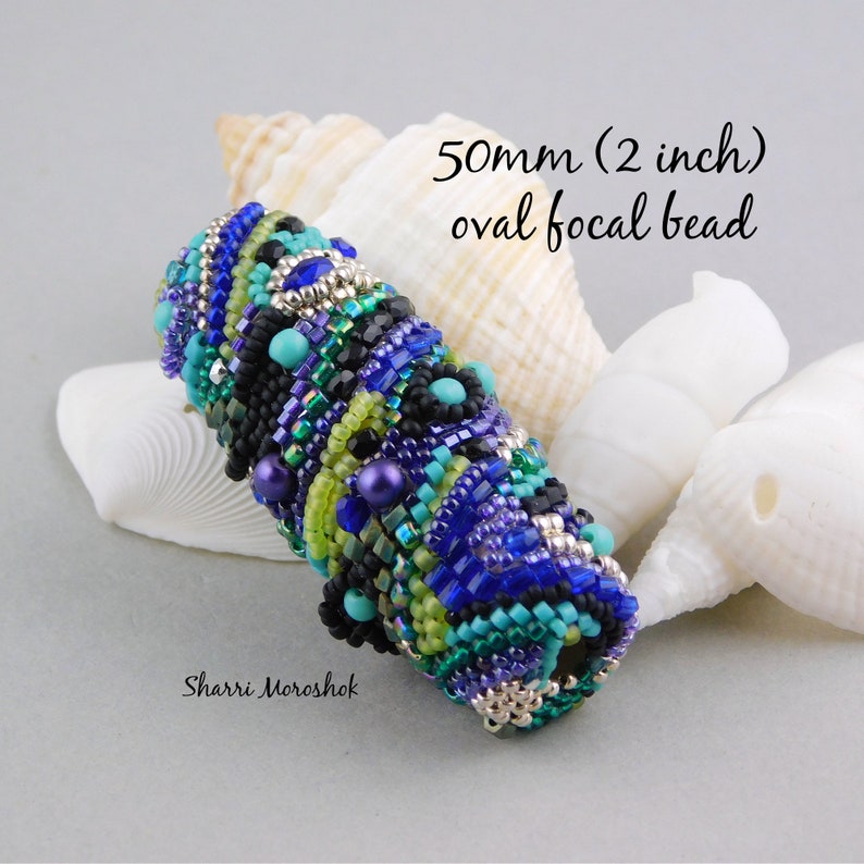 May include: A 2 inch oval focal bead made of blue, green, turquoise, and black beads. The bead is surrounded by seashells.