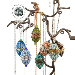May include: Six beaded egg pendants hanging from a metal tree branch display. The pendants are made of various colors of beads, including green, blue, gold, and brown. The pendants are all different shapes and sizes.