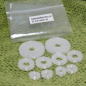 Detailed view of set of 10 translucent crystal 3D printed disc beads in 3 sizes. Precision-made jewelry components with smooth surfaces and clean circular holes in various diameters