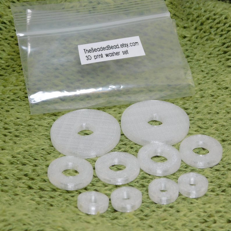 Detailed view of set of 10 translucent crystal 3D printed disc beads in 3 sizes. Precision-made jewelry components with smooth surfaces and clean circular holes in various diameters