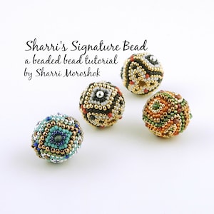 May include: Four beaded balls in different color combinations. The beads are made of small seed beads and feature geometric patterns. The beads are arranged on a white surface. The text "Sharris Signature Bead a beaded bead tutorial by Sharri Moroshok" is visible above the beads.