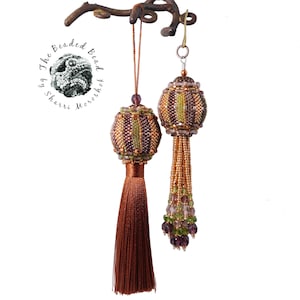 May include: A pair of beaded tassel earrings in a brown and gold colour scheme. The earrings feature a round, beaded ball with a geometric pattern and a long, brown tassel.