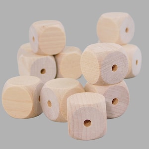 May include: A group of 10 unfinished wooden cubes with a hole in the center of each cube. The cubes are arranged in a pile.