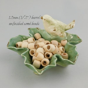 May include: A green ceramic bowl with a bird figurine on top, filled with 12mm (1/2") unfinished wooden barrel beads. 12mm (1/2") barrel unfinished wood beads.