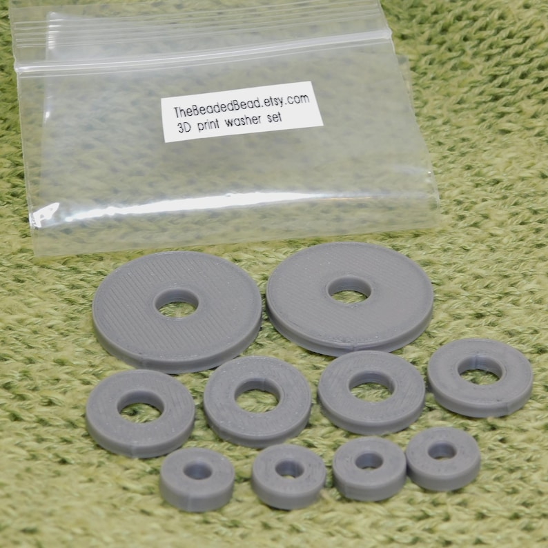 Detailed view of set of 10 silver gray 3D printed disc beads in 3 sizes. Precision-made jewelry components with smooth surfaces and clean circular holes in various diameters