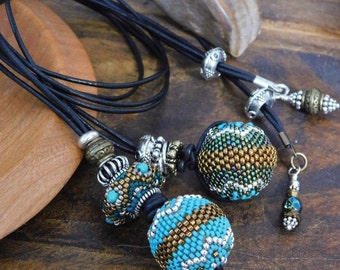 Bead pendants on adjustable length, no clasp, leather cord necklaces, geometric patterned beaded beads by Sharri Moroshok