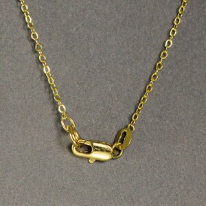 Peut inclure: Un collier en cha&icirc;ne dor&eacute;e avec un fermoir &agrave; ressort.