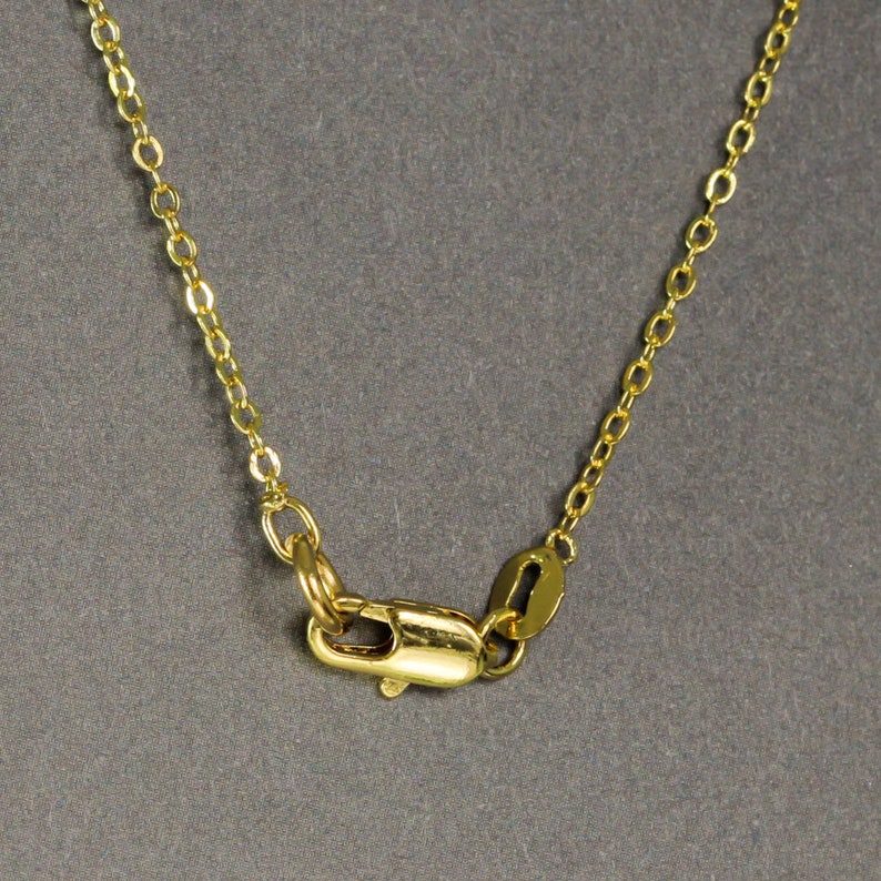 Peut inclure: Un collier en cha&icirc;ne dor&eacute;e avec un fermoir &agrave; ressort.