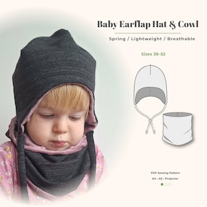 May include: A dark charcoal grey earflap hat and matching cowl set with a soft pink interior lining. The text reads Baby Earflap Hat & Cowl, Spring / Lightweight / Breathable, Sizes 38-52, and PDF Sewing Pattern A4 A0 Projector.