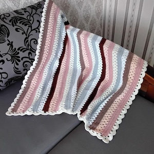 Manta de crochê feita à mão para bebê, em algodão listrado em tons pastel, ideal para berçário, carrinho de bebê ou como presente para recém-nascido.