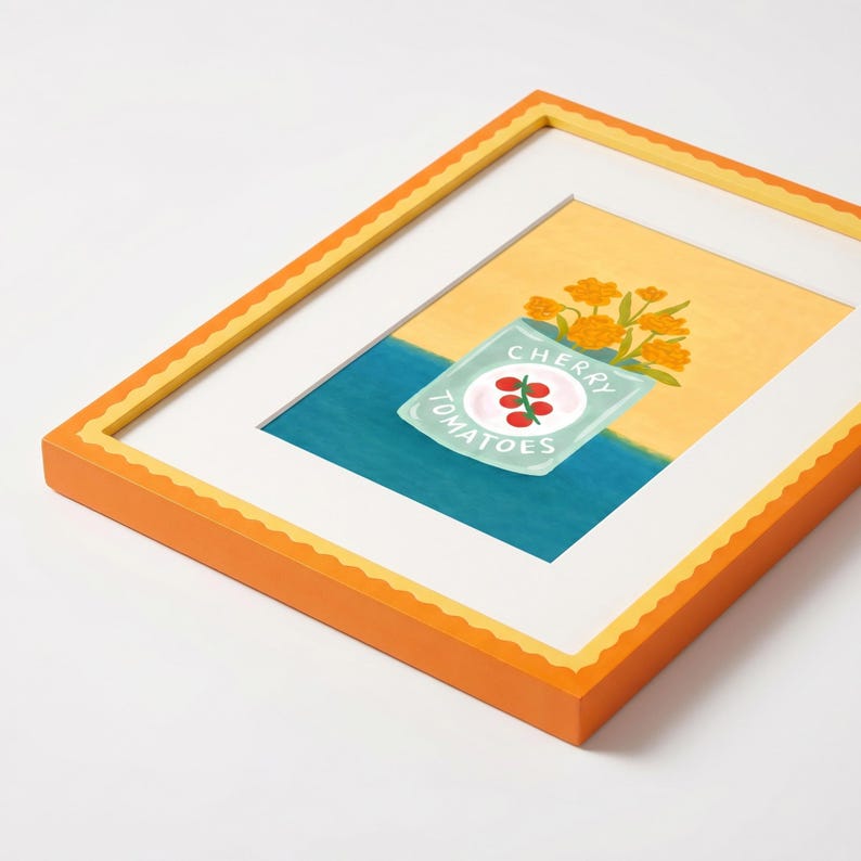 May include: A framed art print featuring a light blue can labeled CHERRY TOMATOES with a red tomato illustration, surrounded by yellow flowers against a yellow and blue background, encased in a bright orange frame with a scalloped inner edge.