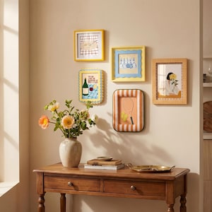 Puede incluir: Una colección de cinco marcos de pared rectangulares con bordes variados, incluyendo diseños amarillos, festoneados y a rayas. Los marcos muestran ilustraciones de una mesa, utensilios de cocina, una botella con texto, una raqueta y una persona.
