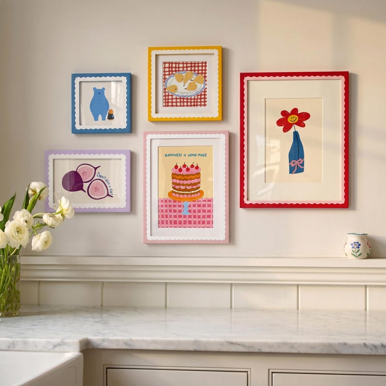 May include: A gallery wall arrangement of five scalloped frames in blue, yellow, pink, and red. The prints feature a blue bear, pears on a red checkered cloth, a red flower in a blue vase, purple figs, and a cake with the text Happiness is Home-made.