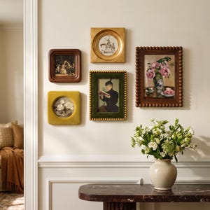 Può includere: Una composizione a parete con cinque opere d'arte incorniciate: una cornice quadrata in legno scuro, una cornice quadrata dorata con apertura circolare, una cornice quadrata in velluto giallo, una cornice verde in velluto perlato e una marrone.