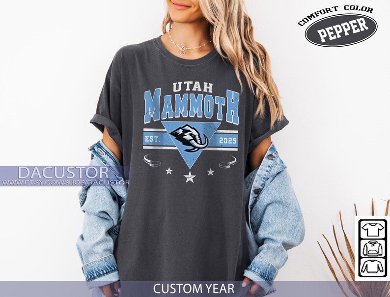K&ouml;nnte beinhalten: Dunkelgraues T-Shirt mit dem Text "Utah Mammoth" in Hellblau und einer Mammut-Grafik in einem blauen Dreieck. Das Shirt enth&auml;lt das Jahr "2025" und die Worte "Comfort Color Pepper". Teil der "Custom Year"-Kollektion.
