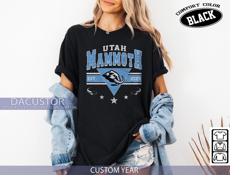 K&ouml;nnte beinhalten: Schwarzes T-Shirt mit dem Text "UTAH MAMMOTH" in Blau und Wei&szlig;, mit einer Mammut-Grafik. Das Shirt enth&auml;lt den Text "EST. 2025" und die Worte "COMFORT COLOR BLACK". Auf der Unterseite des Shirts steht "CUSTOM YEAR".