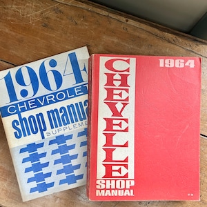 May include: Two vintage shop manuals. One is a 1964 Chevrolet shop manual supplement with blue text and a white background. The other is a 1964 Chevelle shop manual with red cover and white text.