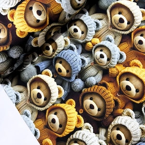 Puede incluir: Un patrón repetido de osos de peluche que llevan sudaderas con capucha de punto en varios colores, incluyendo amarillo, azul y gris. Los osos tienen pelaje marrón, ojos negros y narices cosidas. El fondo es una mezcla de marrón y gris.