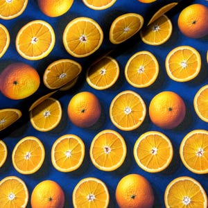 Könnte beinhalten: Ein sich wiederholendes Muster aus ganzen und geschnittenen Orangen auf einem tiefblauen Hintergrund. Die Orangen, ganz und in Scheiben, zeigen ihre leuchtend orange Farbe und saftigen Segmente. Das Design ist ein sich wiederholendes Muster.