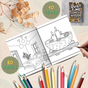 May include: An open coloring book with line drawings of a bedroom and a bowl with candles and flowers. The book is titled "Quiet Time Comfy & Hygge Coloring Book" and has 80 pages and 10 covers. Colored pencils are scattered around the book.