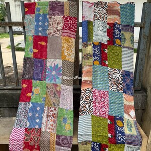 May include: Two patchwork textile panels with a vibrant mix of colours and patterns, including red, blue, green, and yellow. Each panel features a unique arrangement of squares with floral and geometric designs, hanging vertically.