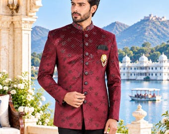 May include: A deep maroon bandhgala jacket featuring a subtle black floral pattern, intricate beadwork, and a high mandarin collar. The jacket is fastened with a row of dark buttons and paired with solid black trousers and black loafers.