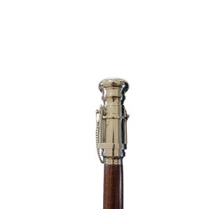 Pu&ograve; includere: Bastone da passeggio color argento con un'asta in legno marrone scuro. La parte superiore del bastone presenta un design metallico decorativo con un piccolo dettaglio a catena. Il bastone &egrave; progettato per il supporto e la mobilit&agrave;.