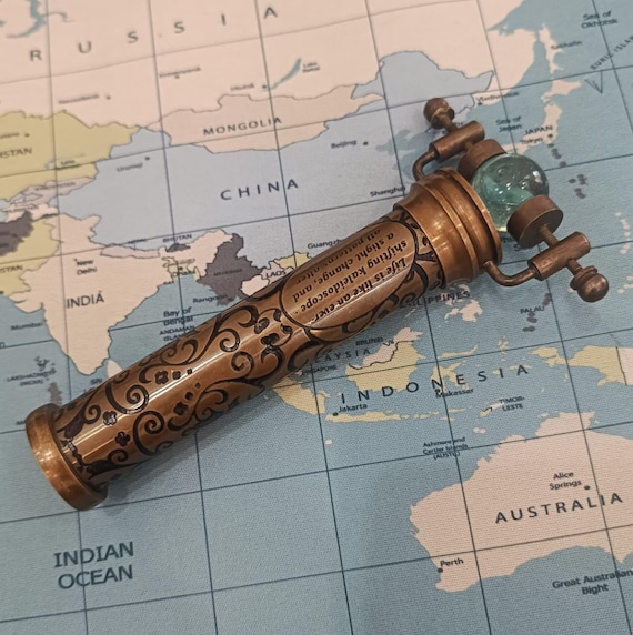 A rotating antique brass kaleidoscope with glass marbles that doubles as a steampunk desk object — genuinely timeless and conversation-starting.