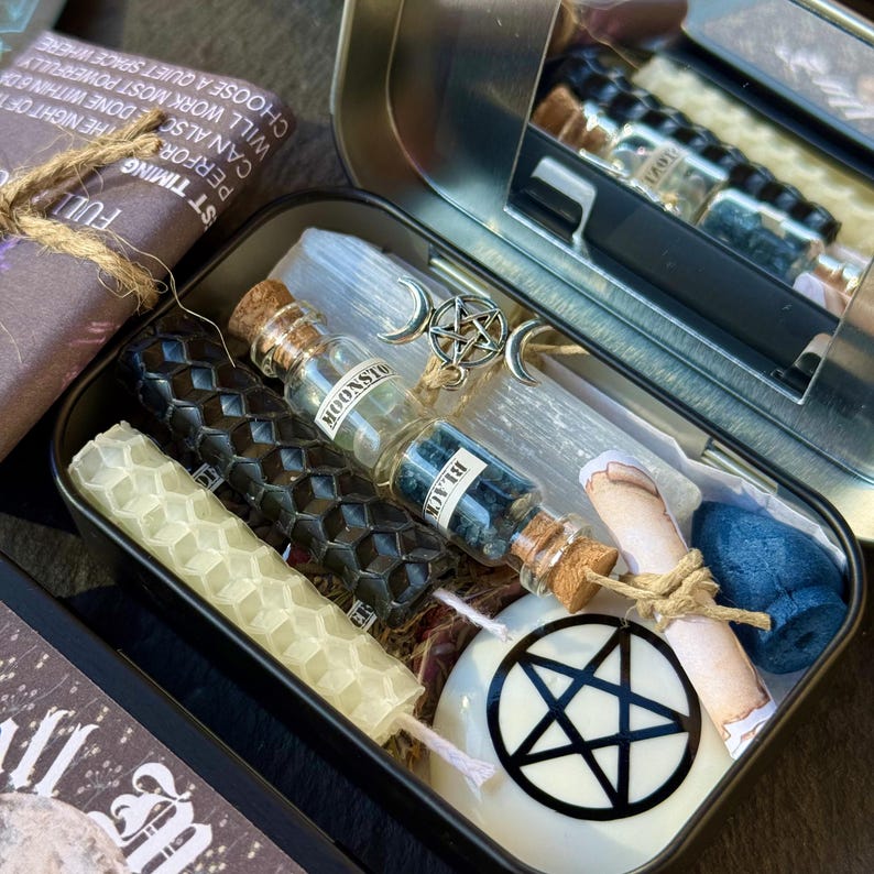 May include: A metal tin filled with spiritual items. Includes black and honeycomb-patterned candles, small glass bottles labeled "MOONSTONE" and "BLACK", a scroll, a pentacle charm, and a white candle with a pentagram.