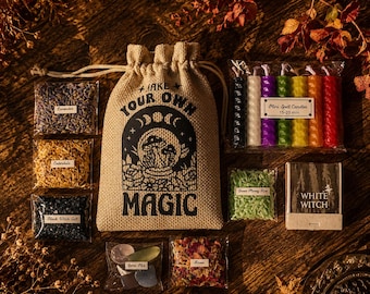 May include: A tan hessian drawstring bag with the text MAKE YOUR OWN MAGIC and a mushroom graphic, surrounded by small clear packets of lavender, calendula, black salt, green rice, rose petals, a gem mix, and a set of six colourful mini spell candles.