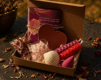 May include: A brown cardboard gift box containing a purple ritual card with text, a brown heart-shaped card, a clear bag of dried flower petals, a bag of small pink crystals, a white seashell, two hexagonal beeswax candles, and a pink incense cone.