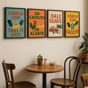 May include: Four framed art prints with black borders hang on a wall. The prints feature colorful illustrations and text in Spanish. One print says "Take it Easy," another "Un Cafecito Pa' Alante," and the others say "Dale Suave" and "Cafecito."