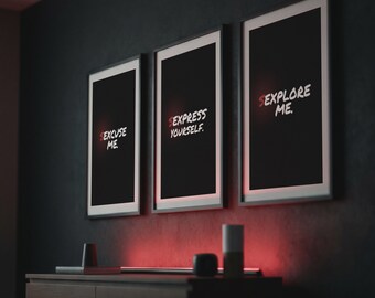 May include: Three framed art prints with black backgrounds and white text that reads "EXCUSE ME," "EXPRESS YOURSELF," and "EXPLORE ME." The frames are white with black borders. The prints are mounted on a dark gray wall above a wooden dresser.