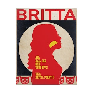 May include: A poster with the name "BRITTA" in red block letters at the top. A red silhouette of a woman's profile is in the center, with a yellow shape on her face. Text below reads "ALL HAIL THE ONE TRUE FIVE! VIVA BRITTA PERRY!!!"