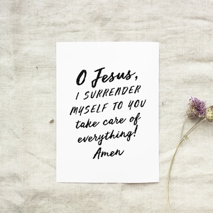 May include: A white card with black text that reads "O Jesus, I surrender myself to you take care of everything! Amen". The card is on a beige fabric background with a dried flower stem.