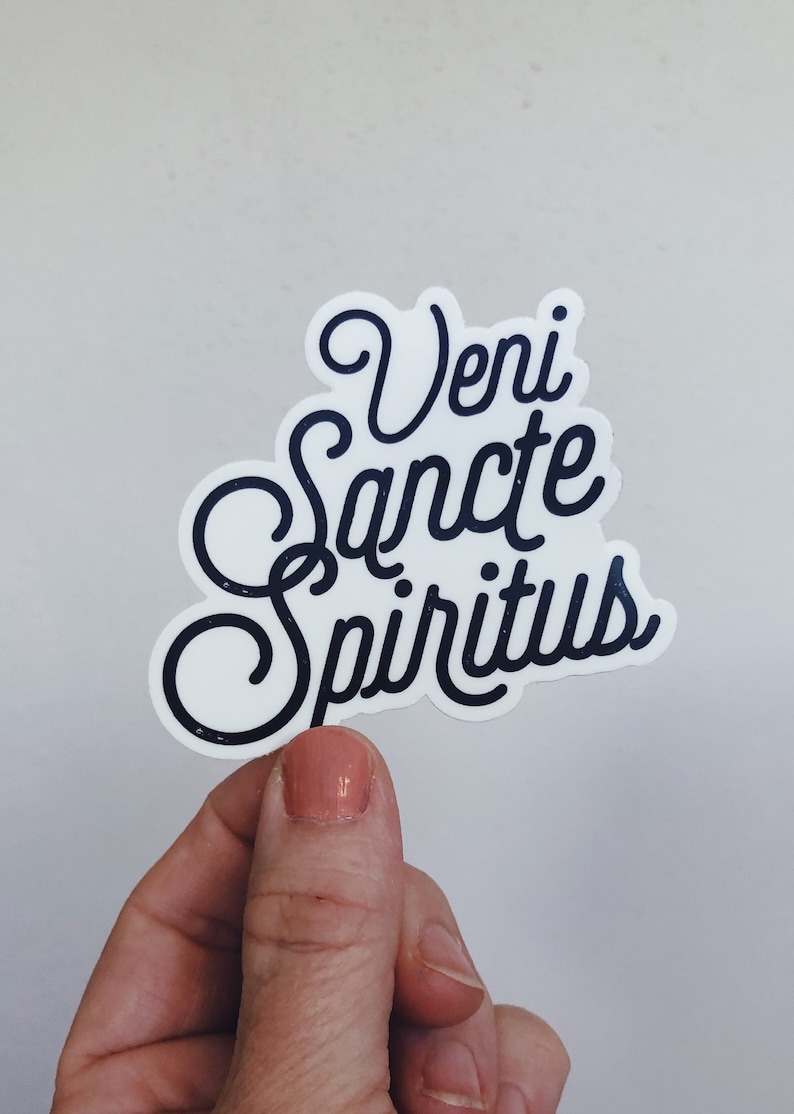 Puede incluir: Pegatina blanca con letras negras que dicen "Veni Sancte Spiritus".