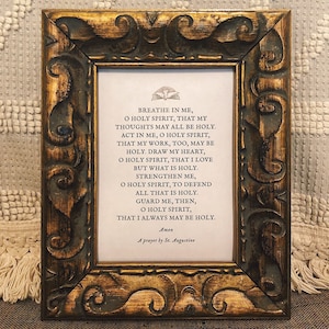 May include: A framed print with a gold-coloured frame and a white background. The print features a prayer to the Holy Spirit, attributed to St. Augustine. The text reads: "Breathe in me, O Holy Spirit, that my thoughts may all be holy. Act in me, O Holy Spirit, that my work, too, may be holy. Draw my heart, O Holy Spirit, that I love but what is holy. Strengthen me, O Holy Spirit, to defend all that is holy. Guard me, then, O Holy Spirit, that I always may be holy. Amen. A prayer by St. Augustine."