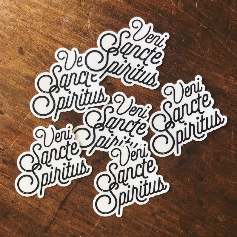 Puede incluir: Seis pegatinas blancas con letras negras que dicen "Veni Sancte Spiritus".