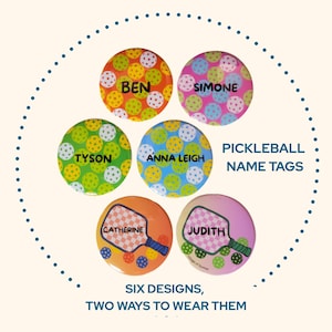 Könnte beinhalten: Sechs farbenfrohe Pickleball-Namensschilder mit verschiedenen Designs und Namen wie Ben, Simone, Tyson, Anna Leigh, Catherine und Judith. Der Text lautet „Pickleball Name Tags“ und „Six Designs, Two Ways to Wear Them“.