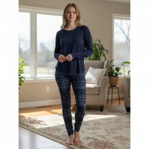 May include: A long-sleeved navy blue crewneck shirt paired with fitted leggings featuring a dark blue, light blue, and white geometric pattern. The shirt has a simple round neckline and long sleeves, while the leggings have a repeating print.
