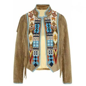 Può includere: Giacca in pelle scamosciata marrone con intricate perline in un motivo geometrico. La giacca presenta frange lungo le maniche e un colletto alto. Le perline incorporano perline blu, rosse, gialle e bianche. La giacca ha una vestibilità su misura e uno stile bohémien unico.