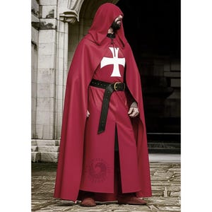 Op de afbeelding: Een rode cape met capuchon en bijpassende tuniek met een wit kruisembleem. De outfit bevat een zwarte riem met een gouden gesp. Het kostuum is geschikt voor historische re-enactments of thema-evenementen.