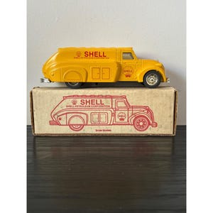 May include: A yellow Shell Petroleum Corporation toy truck with black wheels and a box with a Shell logo. The truck has the Shell logo on the side and the box has a drawing of the truck. The box says "Scale Models".