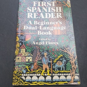 May include: A book titled "First Spanish Reader: A Beginner's Dual-Language Book" with a colourful illustration of a man walking with a donkey on a bridge. The book is edited by Angel Flores.