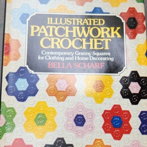 Op de afbeelding: Een boek getiteld "Illustrated Patchwork Crochet" met een omslag met kleurrijke zeshoekige haakpatronen. De titel van het boek staat in grote, gouden letters en de omslag heeft een crèmekleurige achtergrond.